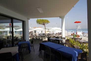 il portico del ristorante con i tavoli a pochi passi dal mare